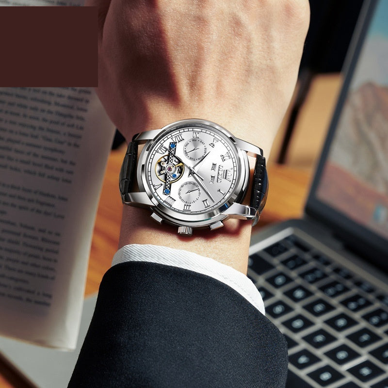 Waterproof luminous multifunctional automatic mechanical watch with silver dial and black leather strap on wrist