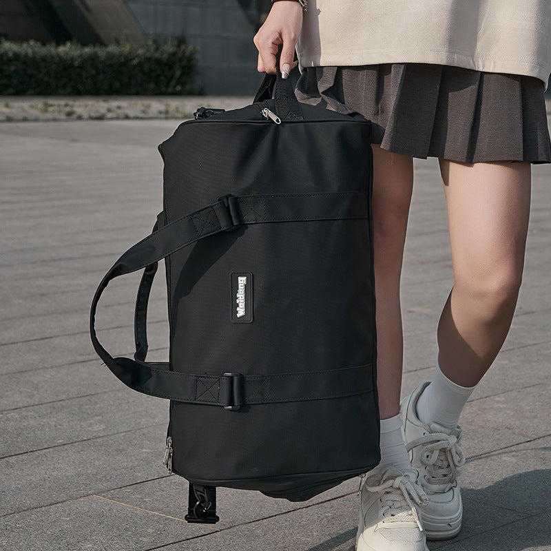 Portable female large capacity swimming bag in black Oxford cloth with shoulder straps carried by a woman outdoors