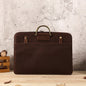 Brown Crazy Horse leather men's business handbag with brass handle and front pocket on wooden surface