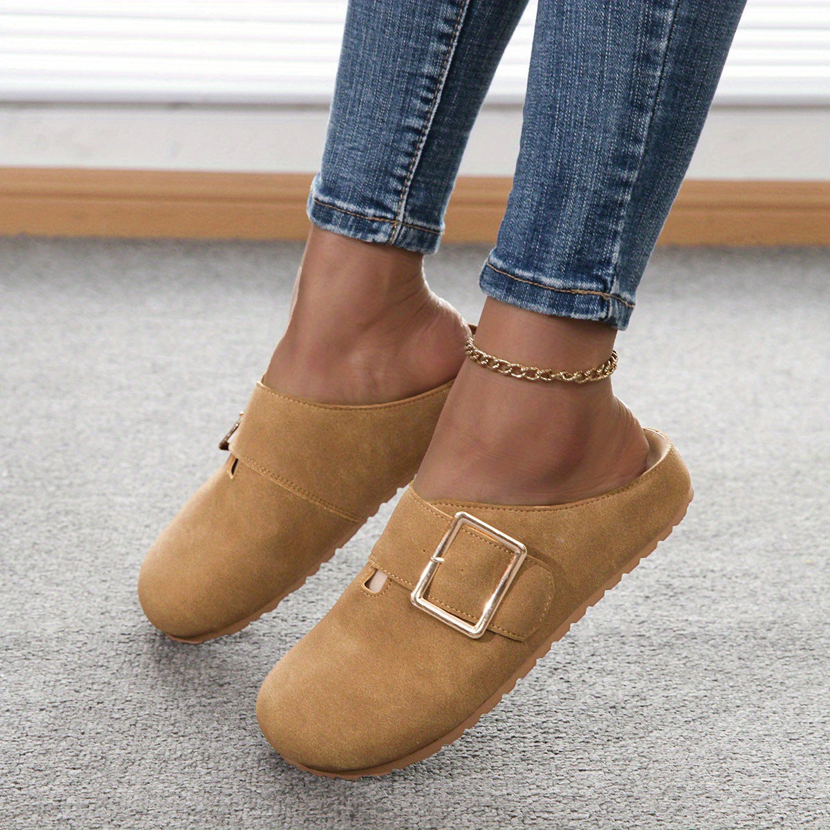 Women's closed toe low top canvas slippers in brown with buckle detail worn with jeans on carpeted floor