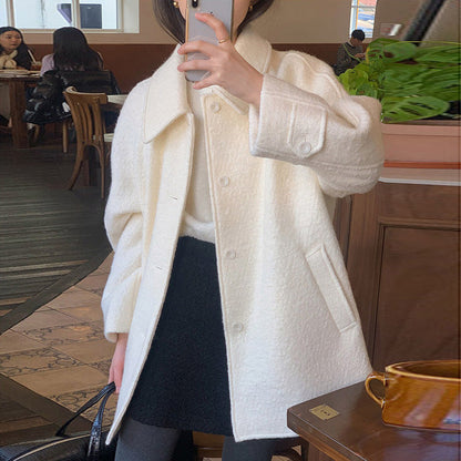 Woman wearing an off-white all-matching long sleeve woolen coat in a cafe setting