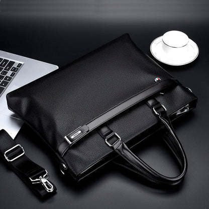 Black large capacity business handbag men's soft leather briefcase with handles and detachable shoulder strap next to laptop and cup
