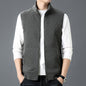 Man wearing gray casual sleeveless top waistcoat over white long sleeve shirt with hands in pockets