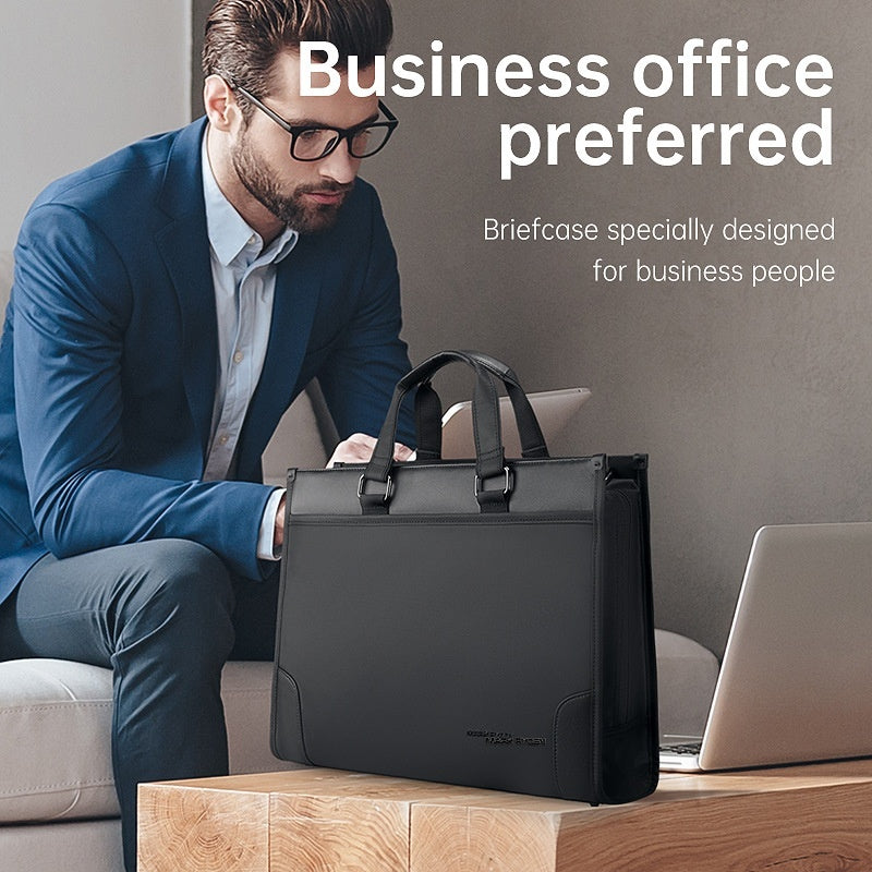 Man in business attire holding a black men's business handheld notebook briefcase next to a laptop on a wooden table