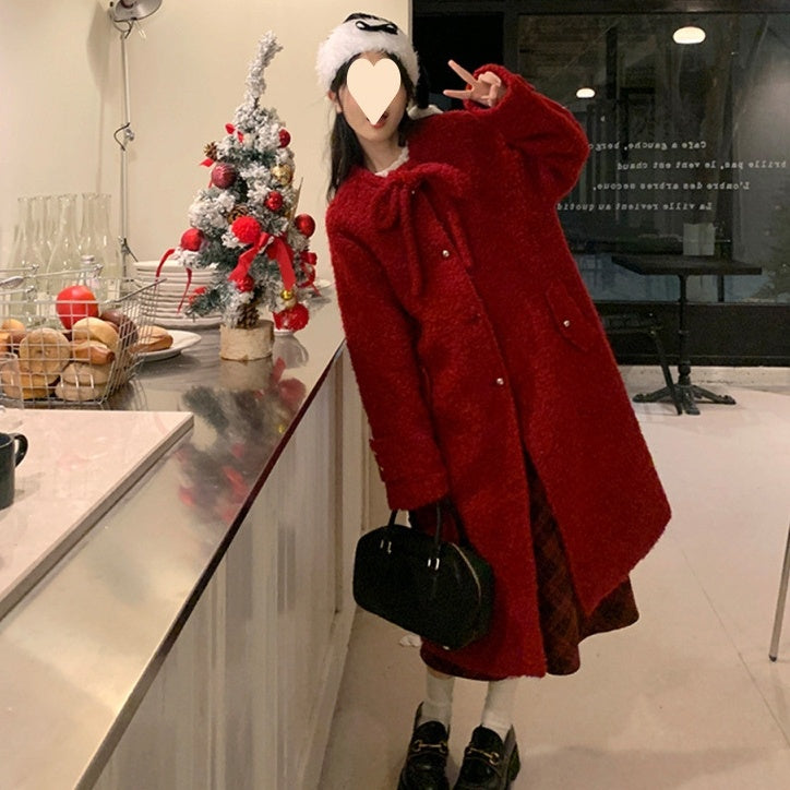Woman wearing a red Korean style woolen overknee long coat indoors by a counter with Christmas decorations
