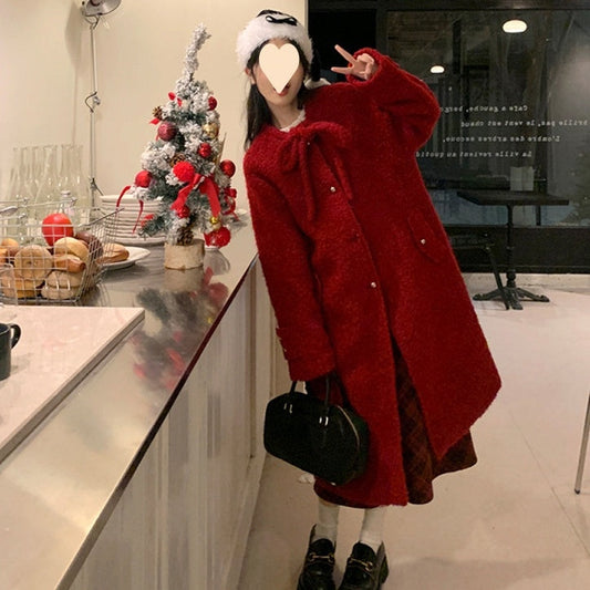 Woman wearing a red Korean style woolen overknee long coat indoors by a counter with Christmas decorations